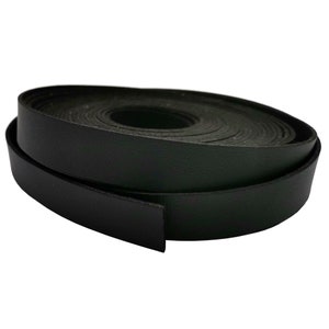 K&ouml;nnte beinhalten: Eine Rolle schwarzes Lederband, etwa 2,5 cm breit, auf einem wei&szlig;en Hintergrund aufgerollt.