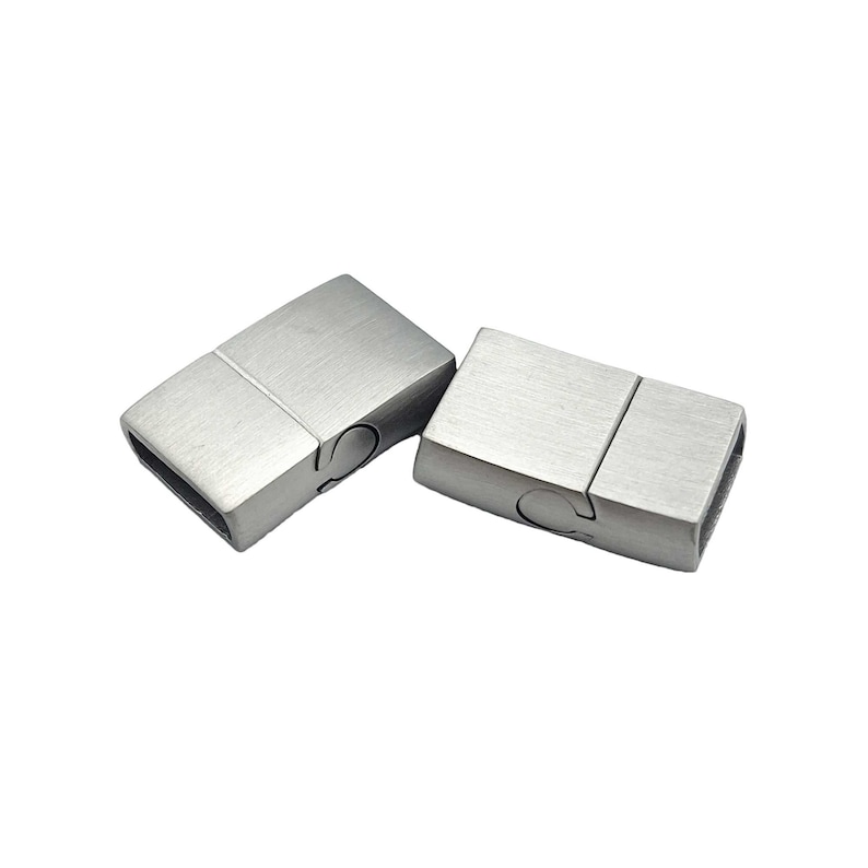May include: Two silver magnetic clasps for jewelry making. The clasps are rectangular and have a brushed finish.