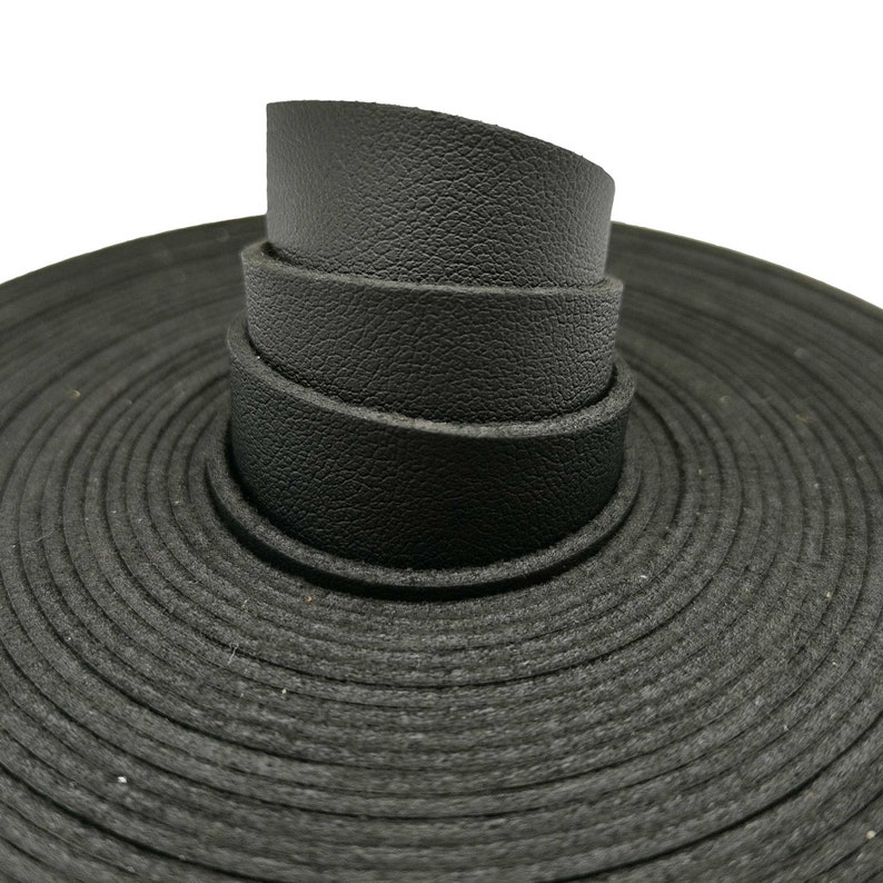 K&ouml;nnte beinhalten: Nahaufnahme einer Rolle schwarzer Lederstreifen, die spiralf&ouml;rmig aufgerollt sind. Das Leder hat eine strukturierte Oberfl&auml;che.
