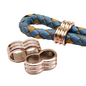May include: Two rose gold metal cord ends with a decorative grooved design. The cord ends are designed to be used with leather cord.