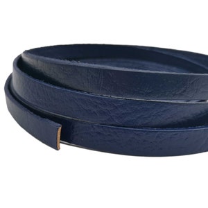 Op de afbeelding: Een rol donkerblauw lederen koord, ongeveer 6 mm breed.