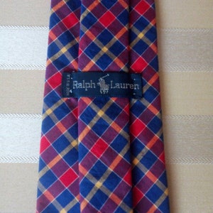 May include: A red, blue, and yellow plaid tie with a black label that reads "Ralph Lauren".