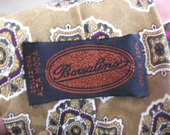 May include: A black fabric label with the text "Borzalino" in a brown oval and the text "Selezione Alta Moda" in white. The label is attached to a brown fabric with a paisley pattern.