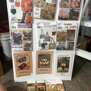 Op de afbeelding: Een verzameling Simplicity naaipatronen en andere knutselpatronen, waaronder tassen, kussens en accessoires. De patronen tonen verschillende ontwerpen en projecten, met tekst zoals "Kimie's Quilts" en "Fabric Central".