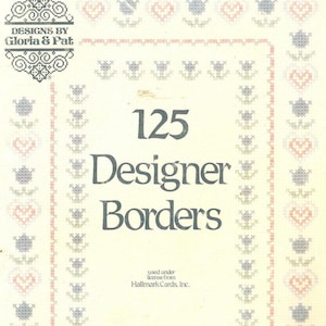 Może przedstawiać: Książka w miękkiej oprawie zatytułowana 125 Designer Borders autorstwa Designs by Gloria & Pat, Book 54. Okładka ma kremowe tło z powtarzającym się wzorem haftu krzyżykowego z niebieskimi kwiatami i różowymi sercami tworzącymi obramowanie, z ciemnoszarym tekstem.