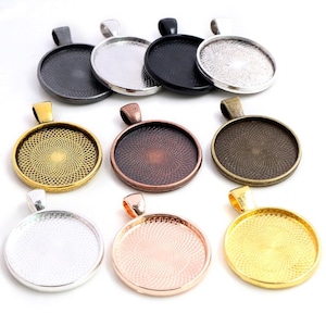 Puede incluir: Surtido de diez bandejas redondas de metal para colgantes con una variedad de acabados, incluyendo plata, oro, bronce, cobre y negro. Cada bandeja tiene un patrón de espiral decorativo y un bucle para colgar.