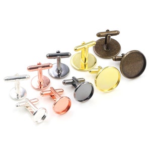 May include: Assortment of cufflinks with different colored round glass cabochons. The cufflinks are made of metal and have a silver, gold, black, copper, and rose gold finish.
