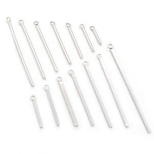 May include: A set of silver-toned head pins with a loop at the top. The head pins are of varying lengths.
