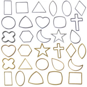 May include: A set of 30 metal cookie cutters in various shapes, including hearts, stars, crosses, moons, and geometric shapes. The cutters are silver and gold in color.