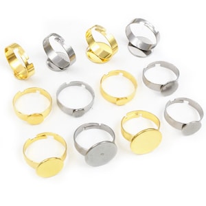 Puede incluir: Un conjunto de 12 anillos ajustables con biseles redondos. Los biseles están disponibles en tonos dorados y plateados. Los anillos son perfectos para crear joyas personalizadas.
