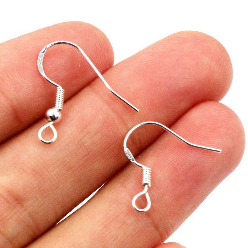 May include: Two silver earring hooks with a spring closure and a small ball at the top of the hook.