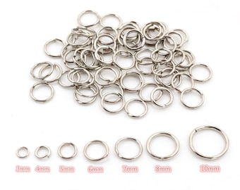 May include: A large pile of silver jump rings in various sizes, ranging from 3mm to 10mm. The rings are arranged in a row from smallest to largest, with the measurements labeled below each ring.
