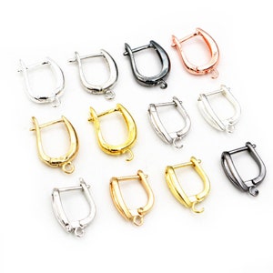 May include: Assortment of earring findings in various finishes, including silver, gold, black, and rose gold. The findings are all in the shape of a U with a small loop at the bottom.