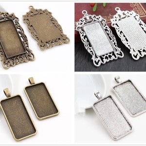 Puede incluir: Una colección de bandejas rectangulares para colgantes en varios acabados metálicos. Las bandejas presentan marcos de filigrana ornamentados y engastes sencillos, perfectos para la creación de joyas. Los colores incluyen bronce antiguo, plata y tonos dorados.