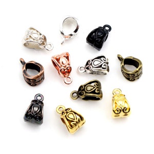 May include: Assortment of ten metal pendant clasps in various finishes, including silver, gold, black, and copper. Each clasp features an ornate design with a teardrop shape in the centre.