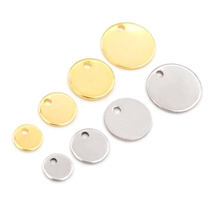 May include: Assortment of round metal charms in gold and silver with a small hole at the top. The charms are different sizes.
