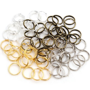 May include: A large assortment of jump rings in gold, silver, and bronze colors. The jump rings are small and circular, perfect for jewelry making or crafting.