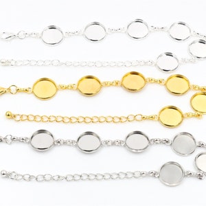 May include: Three silver and gold chain bracelets with round glass cabochons. Each bracelet has a lobster clasp closure.
