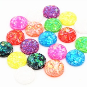 May include: Assortment of 14 round iridescent cabochons in various colors, including pink, green, blue, yellow, and purple. The cabochons are approximately 1 inch in diameter and have a flat back.