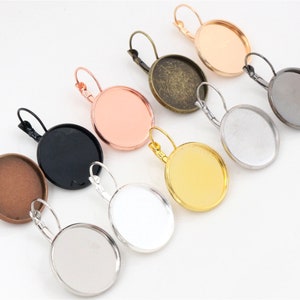 Può includere: Assortimento di otto basi rotonde per orecchini in metallo con diverse finiture di colore. Le basi hanno un diametro di 25 mm e una superficie liscia e lucida. I colori includono oro, argento, nero, rame, oro rosa e ottone antico.