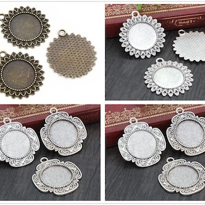 May include: Three sets of silver and bronze pendant trays with different designs. The trays are round and have a raised edge. The trays are perfect for making jewelry or other crafts.