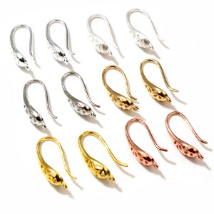 Puede incluir: Un juego de 10 ganchos para pendientes en tres acabados metálicos diferentes: plata, oro y oro rosa. Los ganchos tienen todos el mismo diseño, con un delicado patrón calado.