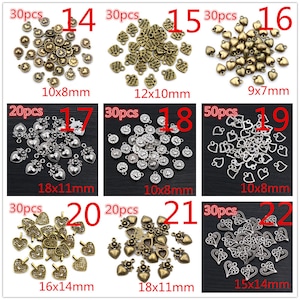 K&ouml;nnte beinhalten: Sortiment von 22 verschiedenen Arten von silbernen und bronzenen herzf&ouml;rmigen Charms. Jeder Charm hat ein anderes Design und eine andere Gr&ouml;&szlig;e. Die Charms sind in einem Rastermuster auf wei&szlig;em Hintergrund angeordnet. Die Charms sind perfekt f&uuml;r die Schmuckherstellung, das Scrapbooking und andere Bastelprojekte.