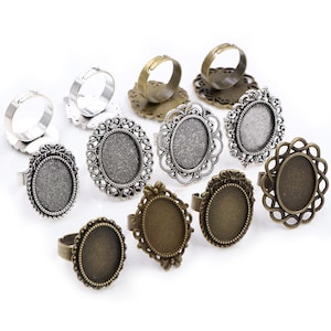 May include: A set of 10 silver and bronze oval ring blanks with decorative filigree edges. The blanks are designed to be used for crafting jewellery.