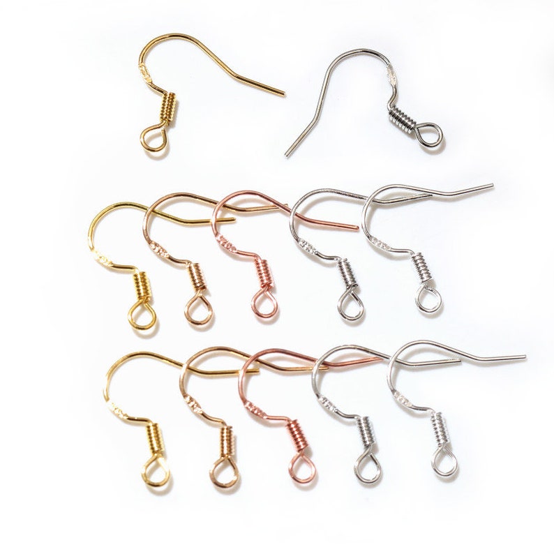 May include: Assortment of earring hooks in gold, silver, and rose gold finishes. The hooks have a spring closure.