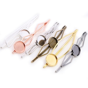 May include: Five hair clips in different coloured metal finishes. Each clip has a round, clear glass cabochon in the centre.