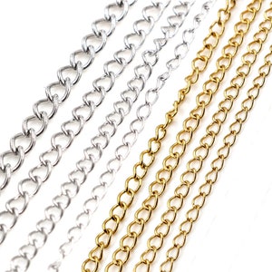 May include: A close-up of multiple silver and gold chains. The chains are arranged in a row, with the silver chains on the left and the gold chains on the right.