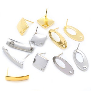 May include: Assortment of earring blanks in gold and silver tones. The blanks are in various shapes, including square, oval, and curved bar.
