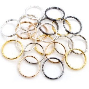 Könnte beinhalten: Ein Haufen verschiedener Schlüsselringe aus Gold, Silber und schwarzem Metall.