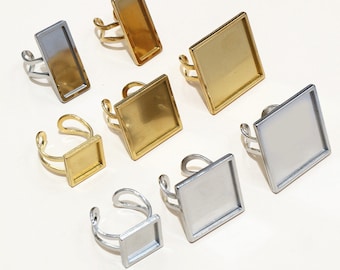 May include: Assortment of gold and silver ring blanks with square and rectangular shaped glass inserts. The ring blanks are made of metal and have a smooth finish.