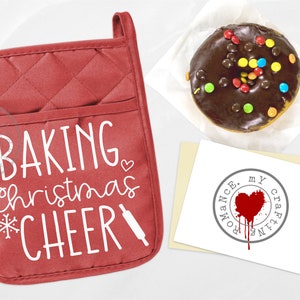 May include: Red quilted oven mitt with the text "Baking Christmas Cheer" in white with a snowflake and rolling pin graphic.