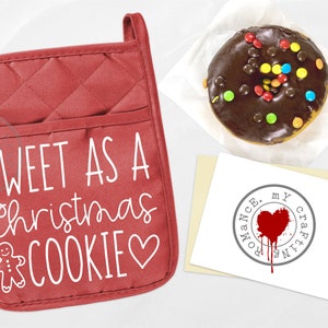 May include: Red quilted oven mitt with the text "SWEET AS A christmas COOKIE" in white with a gingerbread man and a heart.