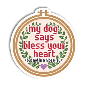 May include: A circular sticker with a tan border. The text "my dog says bless your heart but not in a nice way" is in a red pixelated font. Green leaves and a purple heart decorate the design, creating a humorous and sarcastic theme.