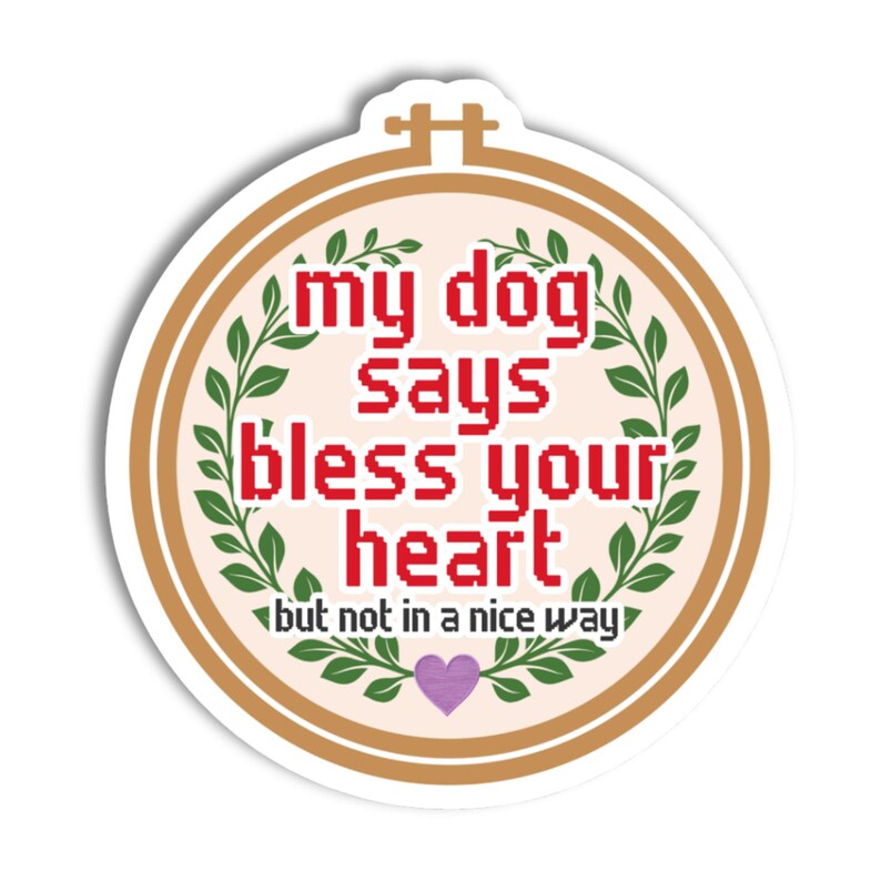 May include: A circular sticker with a tan border. The text "my dog says bless your heart but not in a nice way" is in a red pixelated font. Green leaves and a purple heart decorate the design, creating a humorous and sarcastic theme.