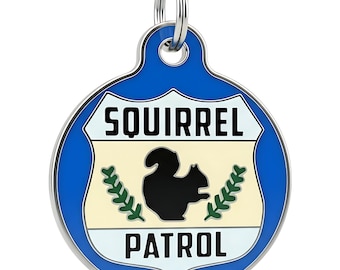 May include: A round blue metal pet ID tag featuring a white shield-shaped center with the black text SQUIRREL PATROL, a black silhouette of a squirrel, and two green leafy branches on either side, complete with a silver metal attachment ring.