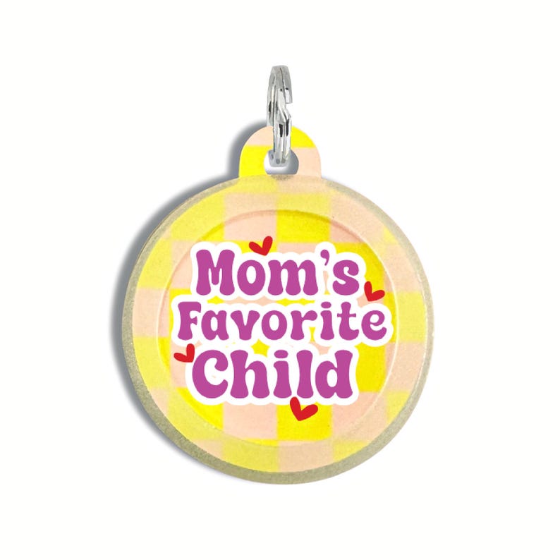 May include: Round yellow and pink checkered pet tag with the text "Mom's Favorite Child" in purple with red hearts.