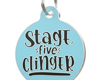 May include: A light blue pet tag with a silver-coloured ring. The tag has the words "Stage five clinger" in black lettering with a white outline. The word "five" is in a decorative font.