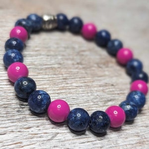 May include: A bracelet made of blue and pink beads. The blue beads have a speckled pattern. The bracelet has a silver clasp.
