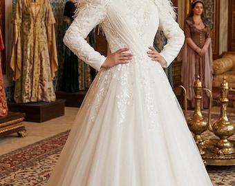 Abito da sposa a maniche lunghe con dettagli in piume, abito da sposa con paillettes, abito da sposa a collo alto, abito da sposa chic, abito da sposa riciclato