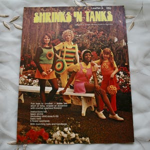 May include: A vintage crochet pattern booklet featuring four girls wearing colorful crocheted tops and skirts. The booklet cover features the title "Shrinks 'N Tanks" and instructions for making crochet tops and skirts.