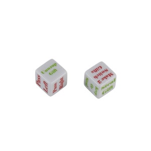 May include: Two white dice with red and green text. The dice are used for a game called "Gift Exchange". The text on the dice includes "Unwrap Gift", "Pass Left", "Pass Right", "Steal Gift", "Make 2 Keep", "Switch Or", and "Gifts".