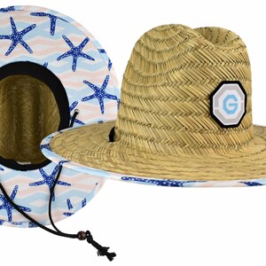 May include: A straw hat with a blue and white starfish pattern on the brim. The hat has a brown woven band and a small patch with a letter "G" on the front.