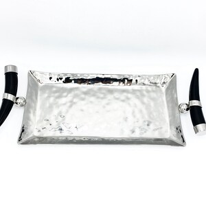 May include: A silver rectangular serving tray with hammered texture and black horn handles.