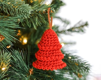 May include: A red crocheted Christmas tree ornament hanging on a green Christmas tree.