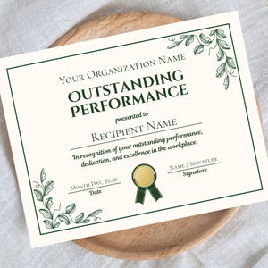 May include: A certificate with the words "OUTSTANDING PERFORMANCE" in dark green font. The certificate has a gold seal and green ribbon, with decorative green floral elements in the corners. The text reads "presented to RECIPIENT NAME".