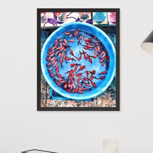 May include: A blue plastic bowl filled with bright red goldfish. The bowl is sitting on a tiled surface with a colorful pattern.